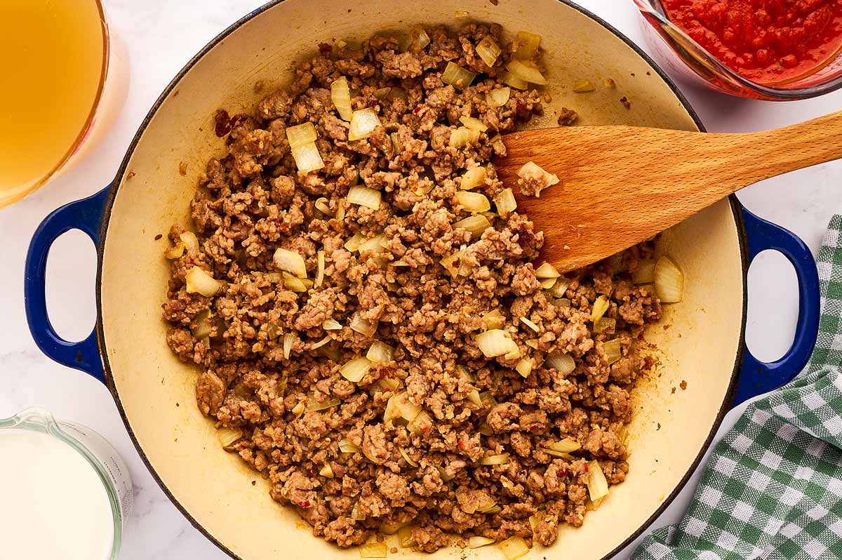 Browning sausage and onion in a skillet.
