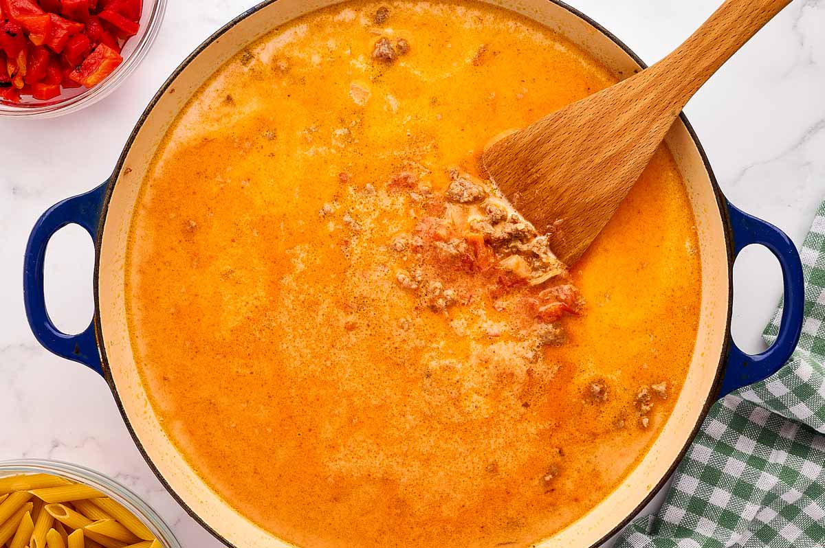 Sauce in skillet with a wooden spatula.
