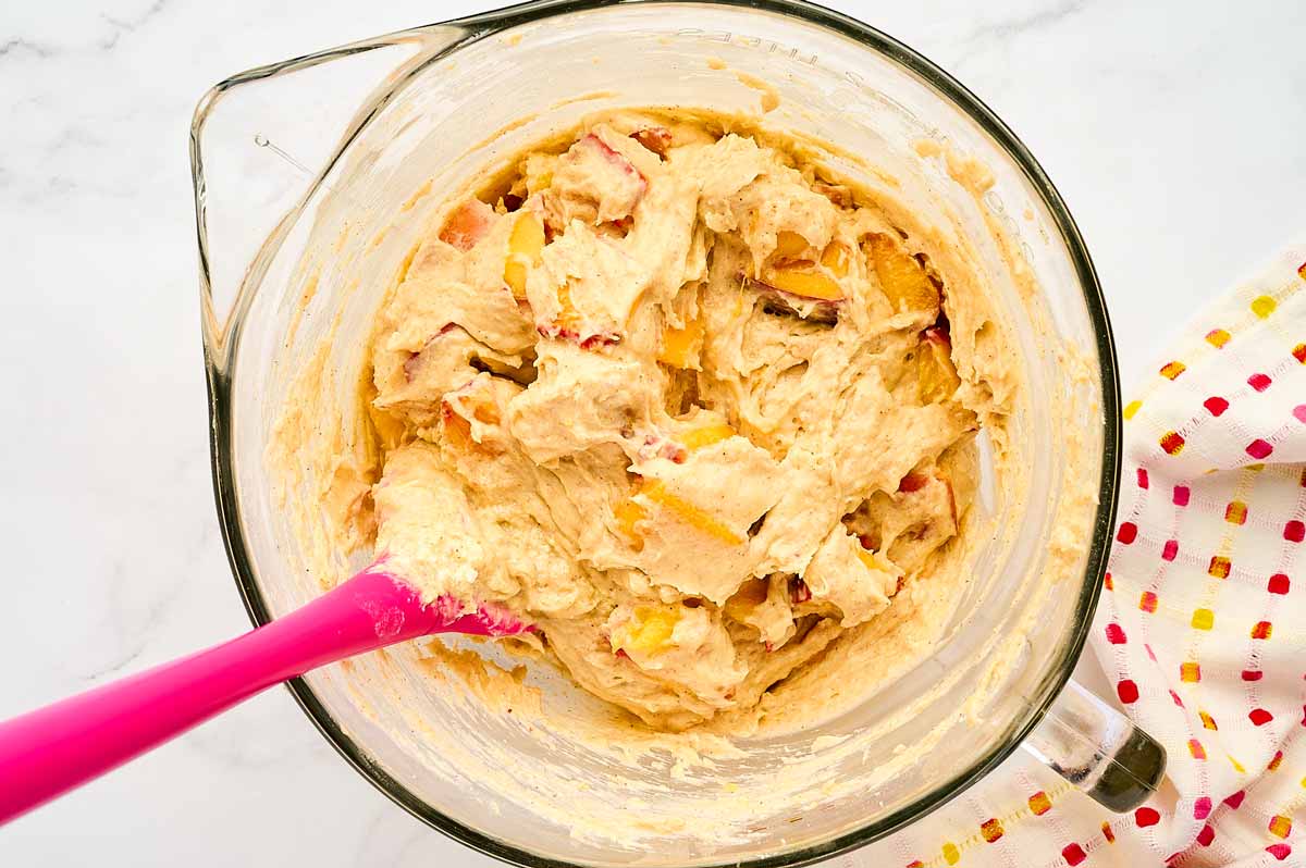 Peach cake batter in a glass bowl.