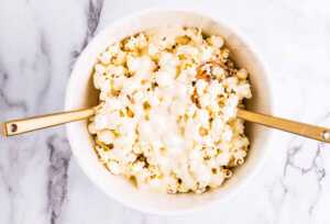 Tossing popcorn, pretzels and peanuts with melted vanilla almond bark.