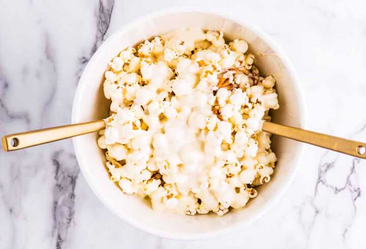 Tossing popcorn, pretzels and peanuts with melted vanilla almond bark.