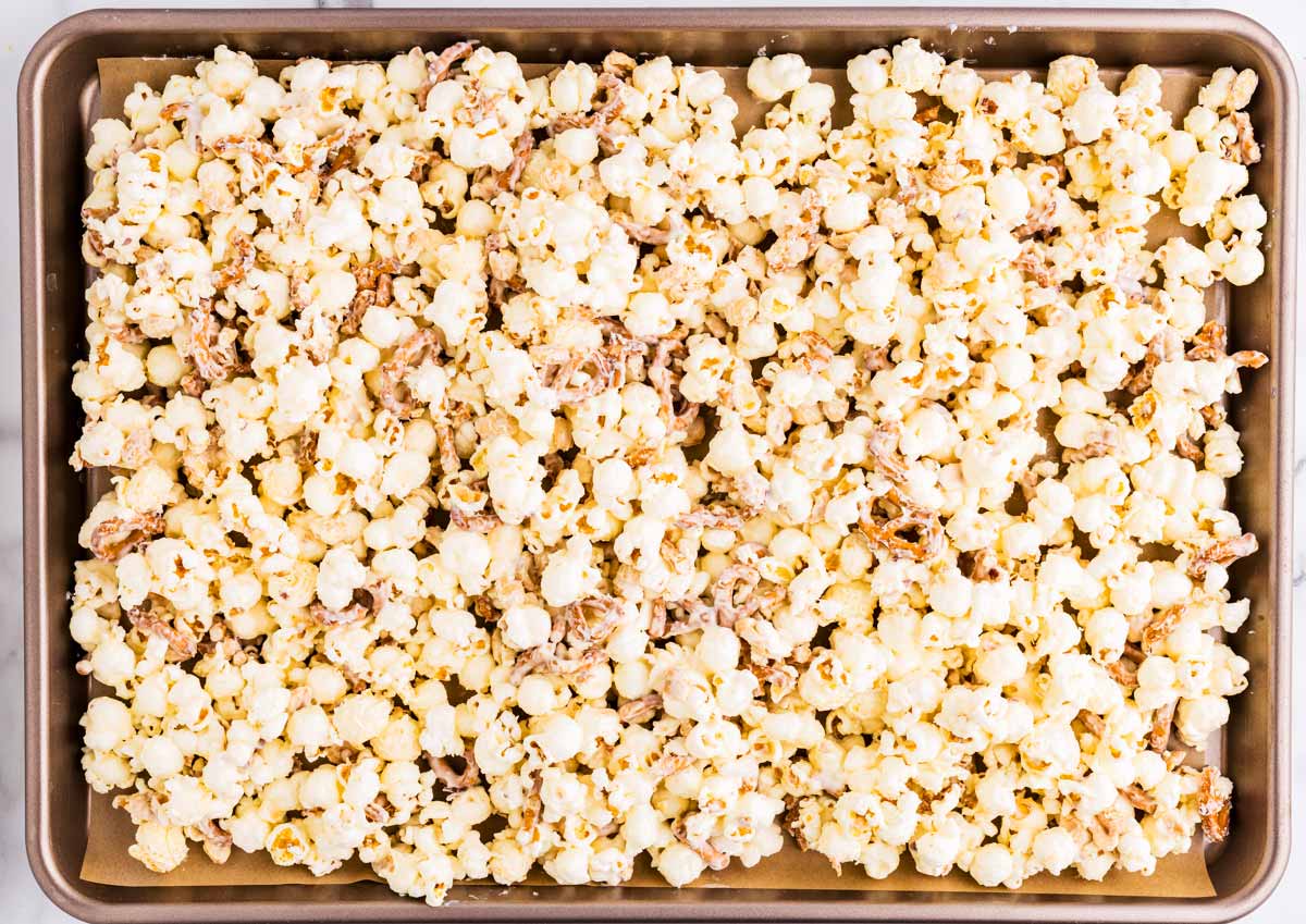 Plain popcorn and white chocolate on sheet pan.