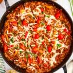 Overhead view of a skillet with unstuffed peppers.
