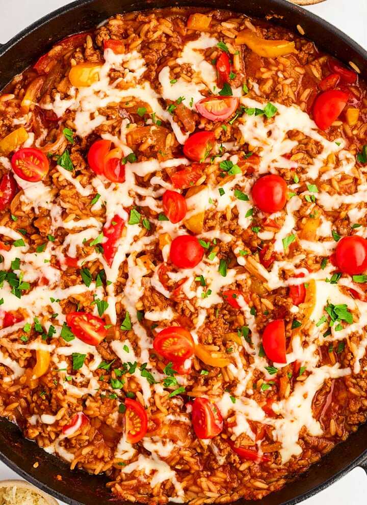 Overhead view of a skillet with unstuffed peppers.
