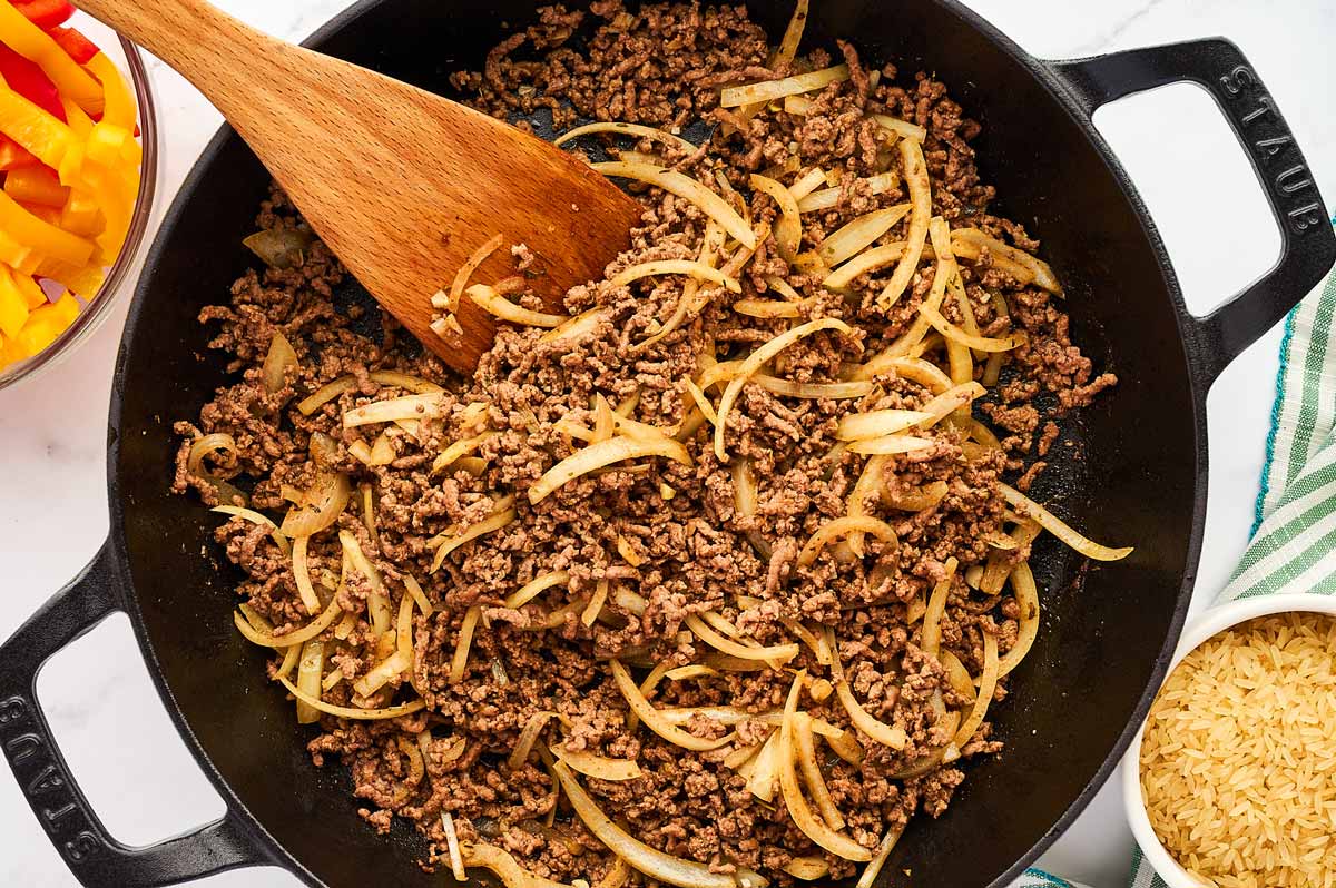 Ground beef in skillet with onions.