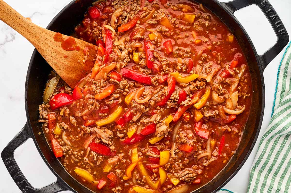 Uncooked unstuffed peppers in skillet.