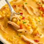 Spoon in a bowl with corn chowder.