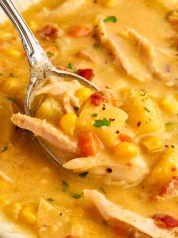 Spoon in a bowl with corn chowder.
