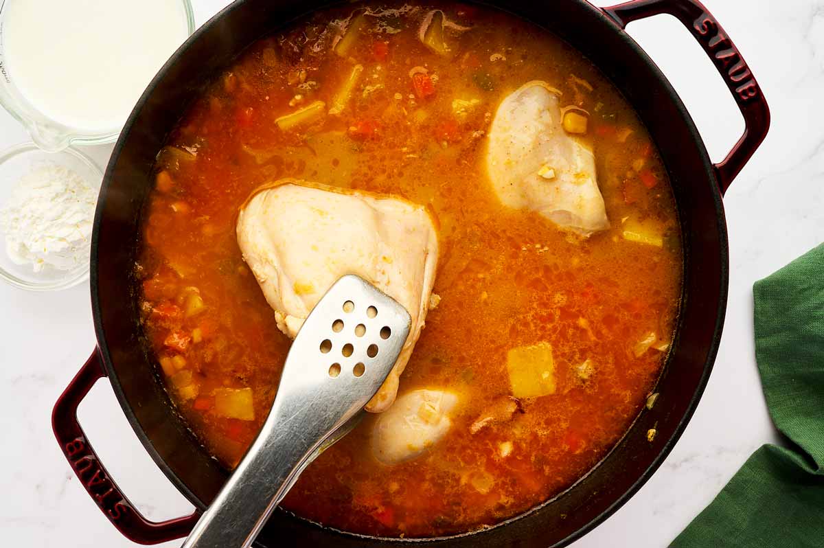 Removing cooked chicken pieces rom corn chowder.
