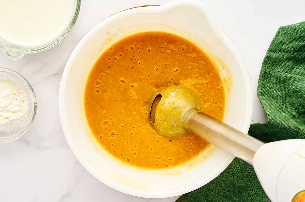 Blending chowder with a stick blender.