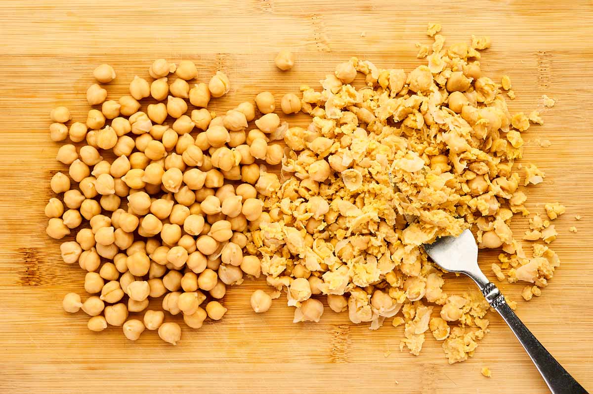 Smashed chickpeas on a cutting board.
