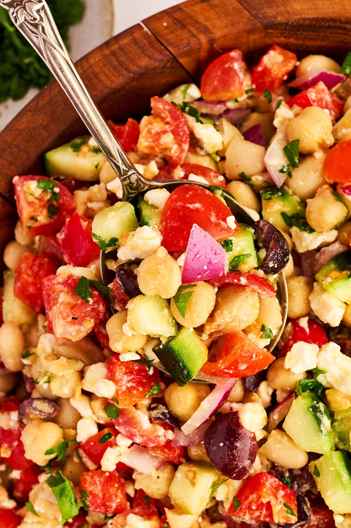 Close up photo of a spoon in Greek Chickpea Salad.