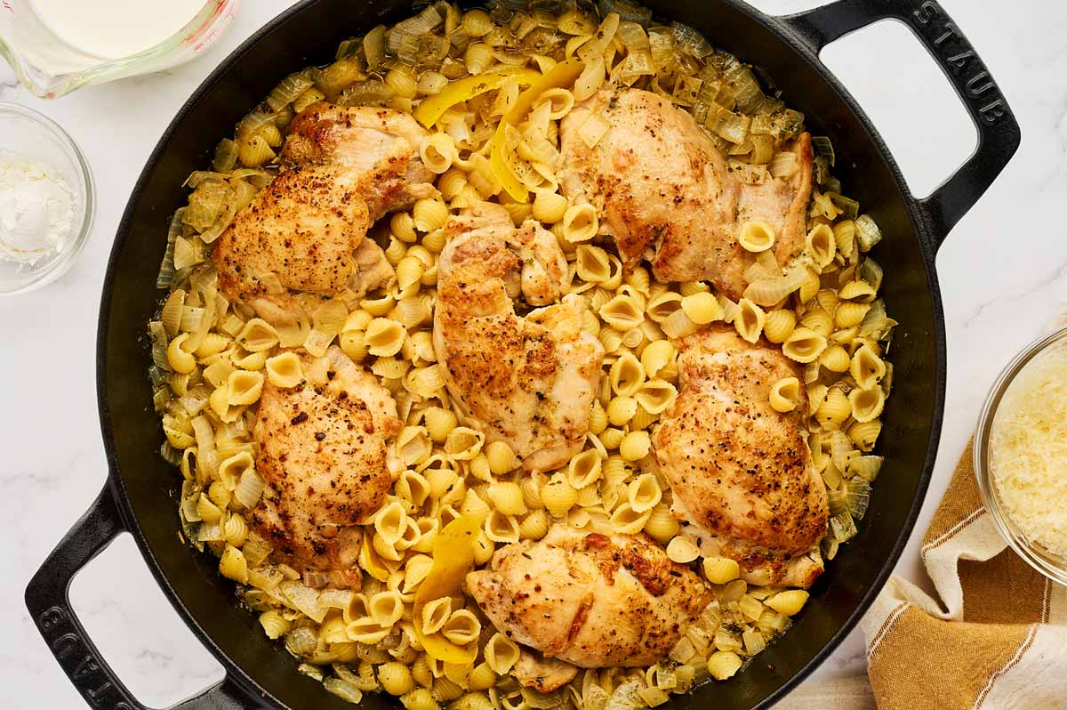 Cooked chicken and pasta in a cast iron skillet.