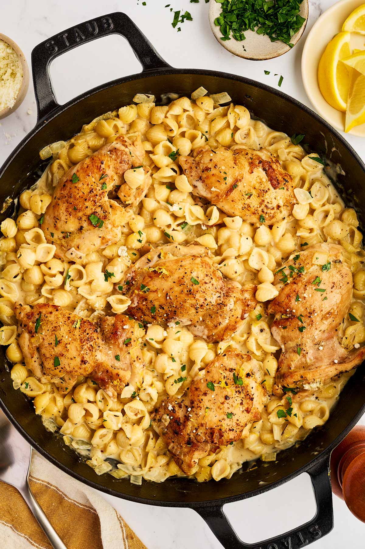 Skillet with creamy pasta and juicy chicken thighs.