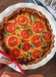 Person holding tomato pie.