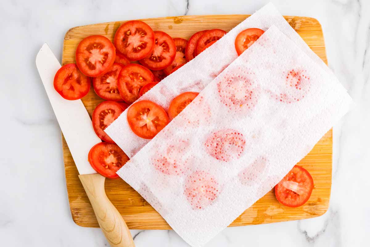 Tomato slices between paper towels.
