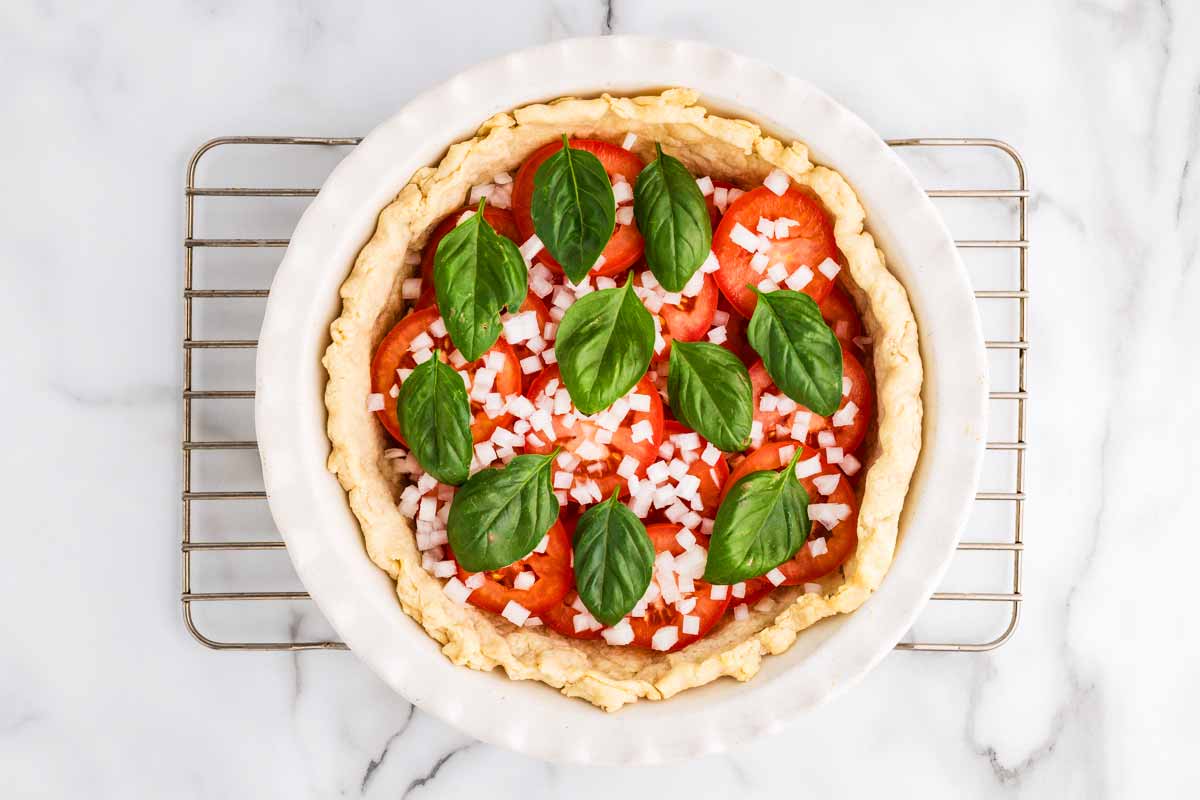 Assembling tomato layer in a tomato pie.