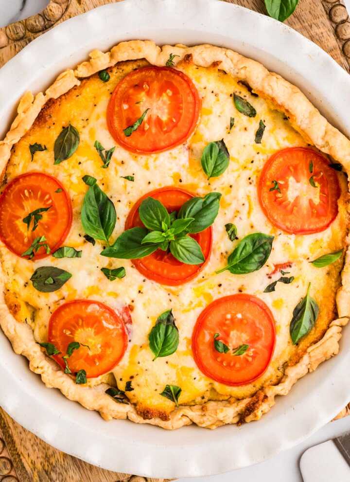 Baked tomato pie on a wooden board.