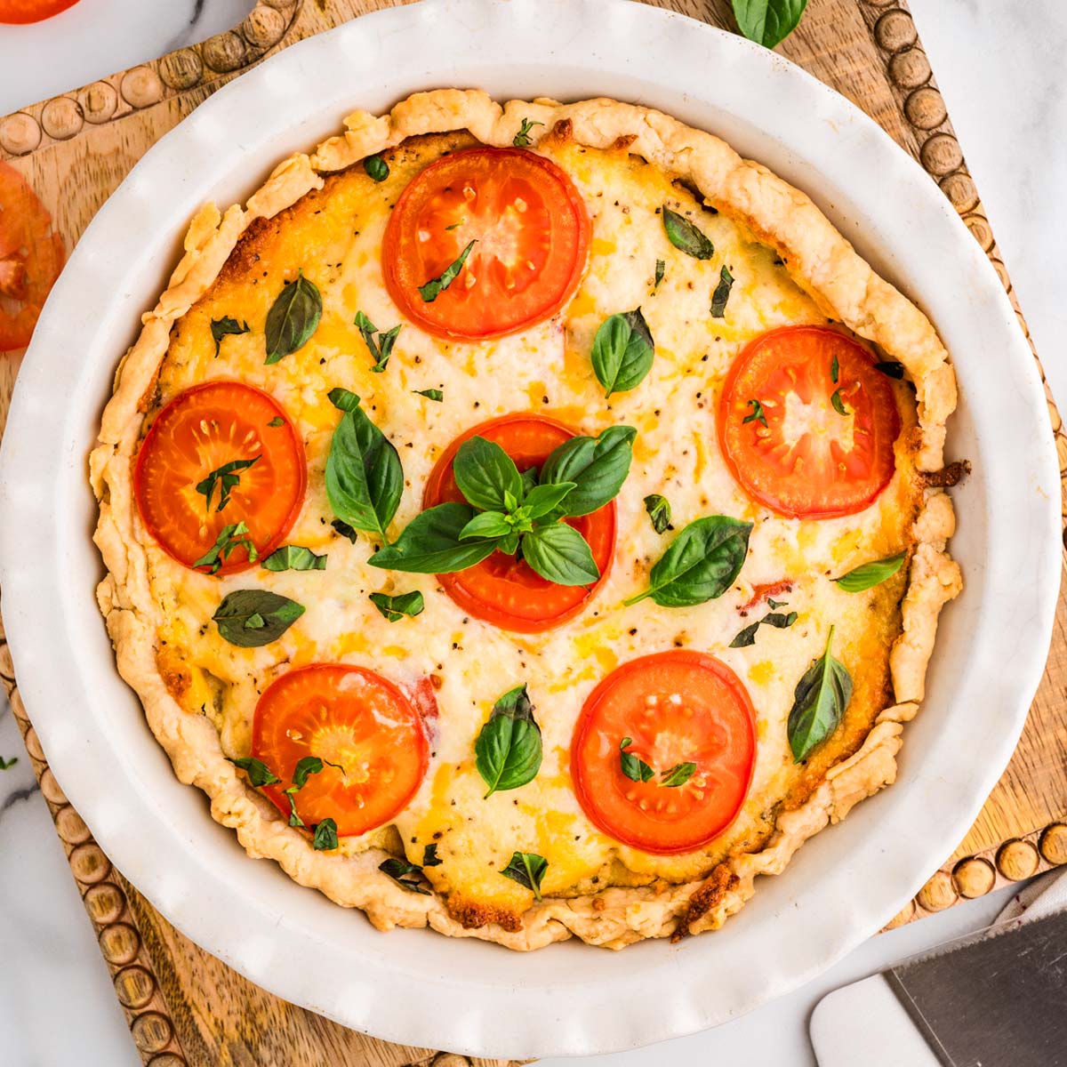 Baked tomato pie on a wooden board.