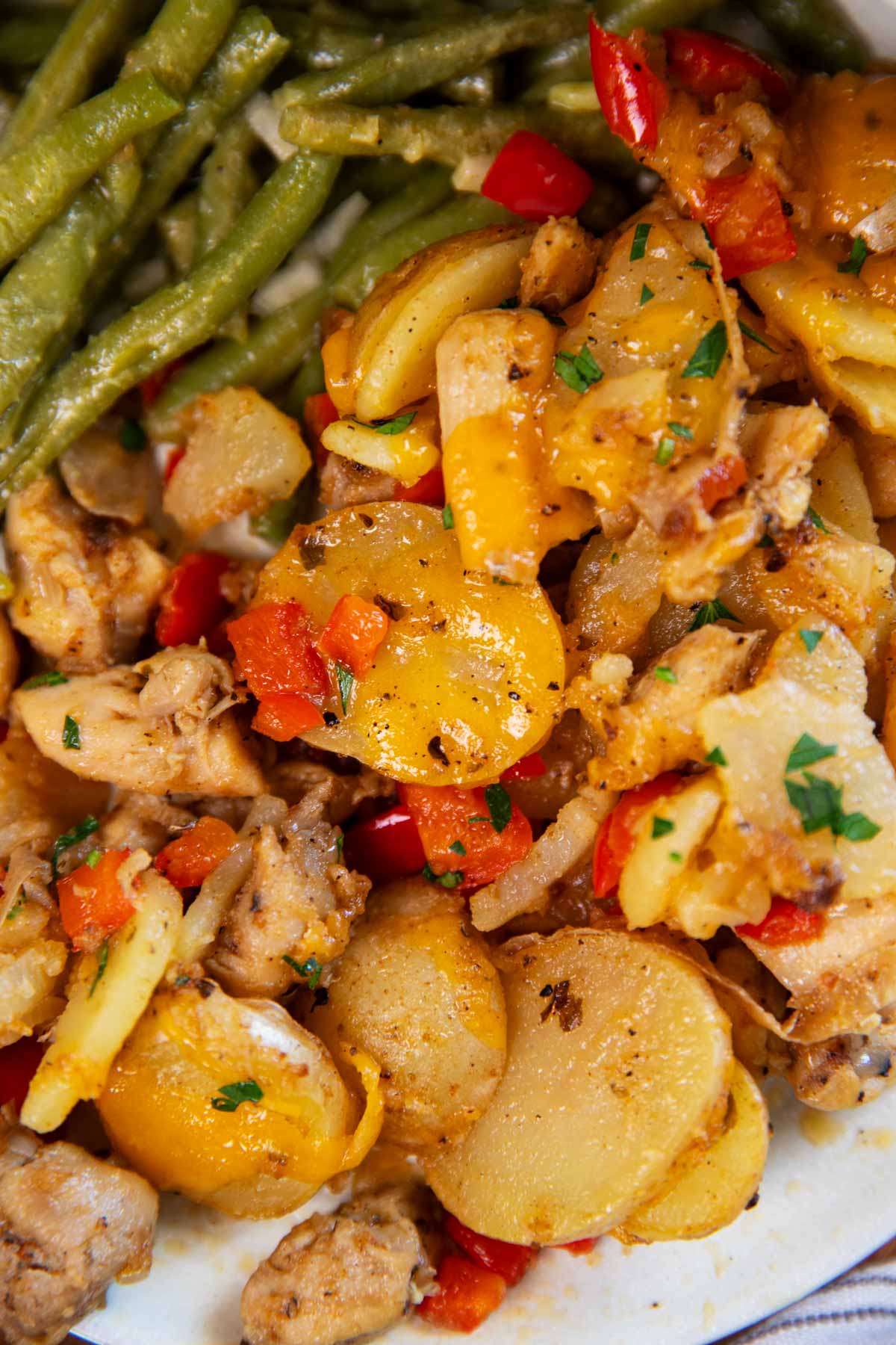 Close up of Cajun Chicken and Potatoes with green beans on a plate.