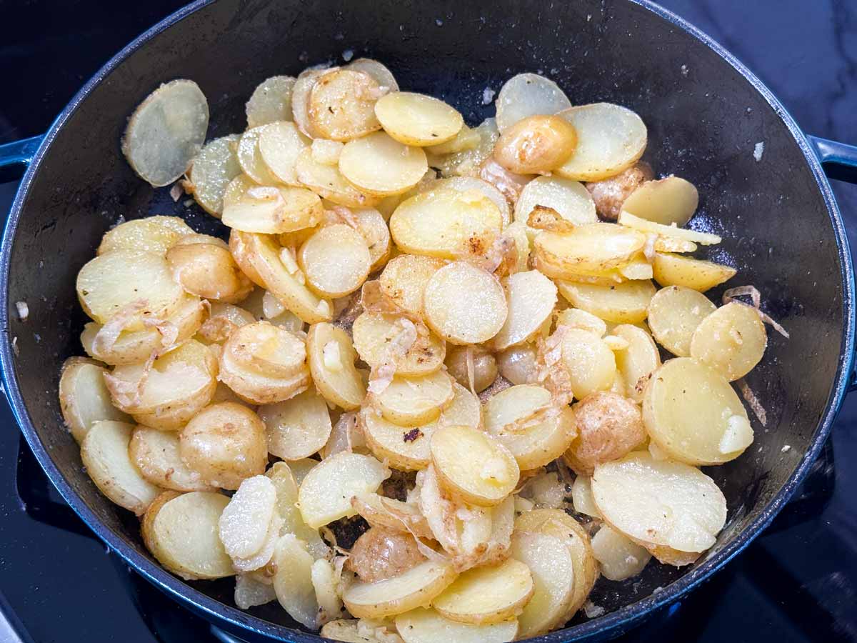 Sliced potatoes in a cast iron skillet.