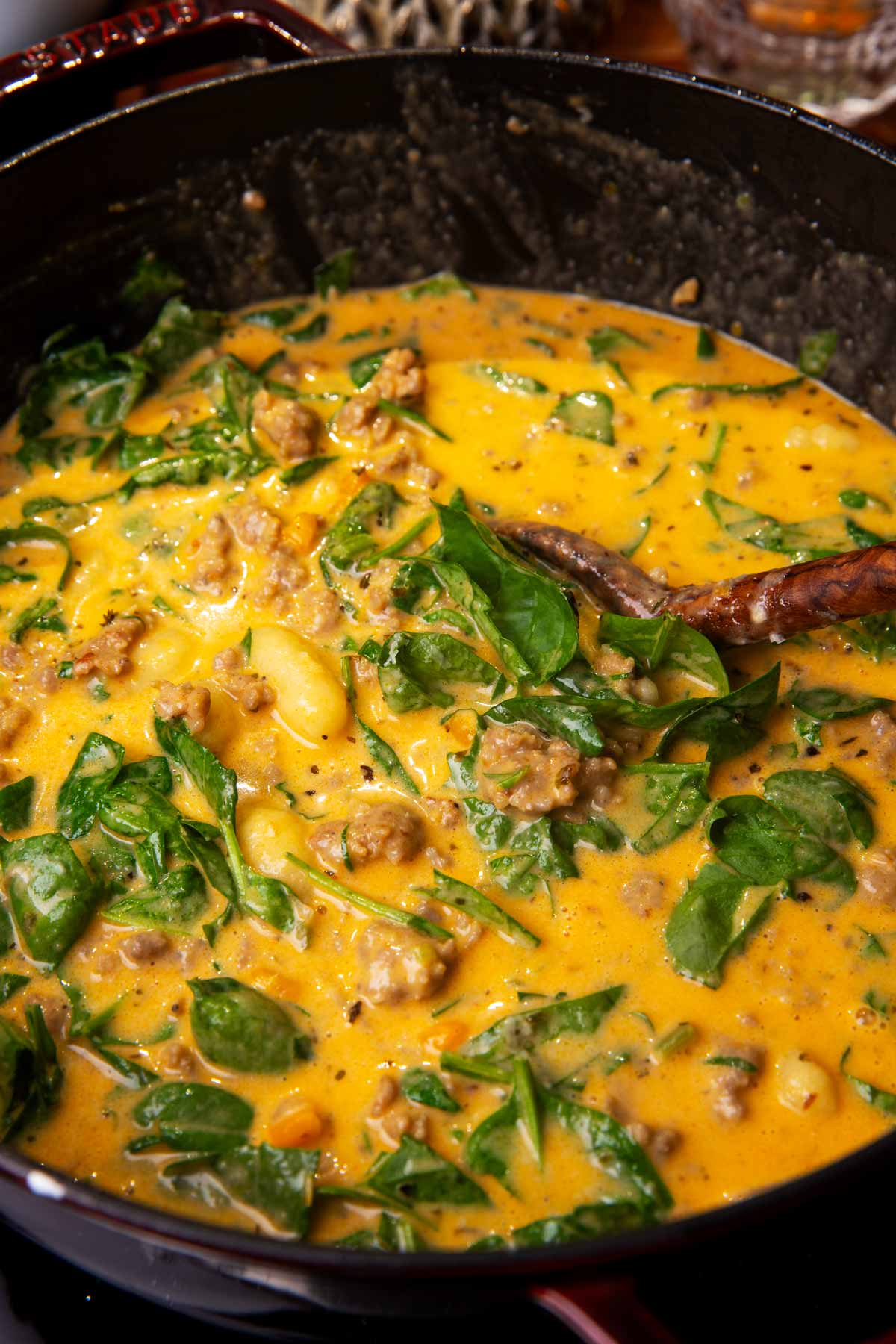 Sausage gnocchi soup simmering in cast iron pot.
