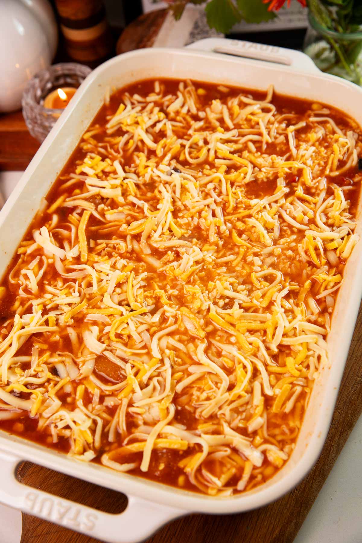 Unbaked chicken and rice casserole with cheese on top.