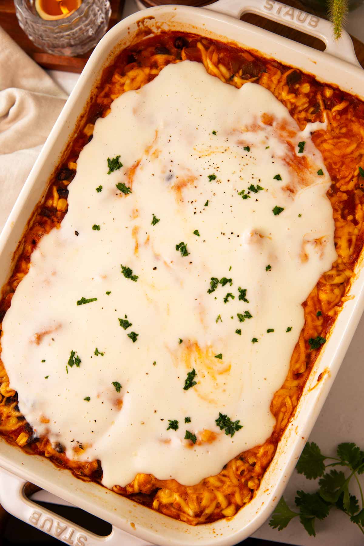 Overhead view of swim queso chicken in a white casserole dish.