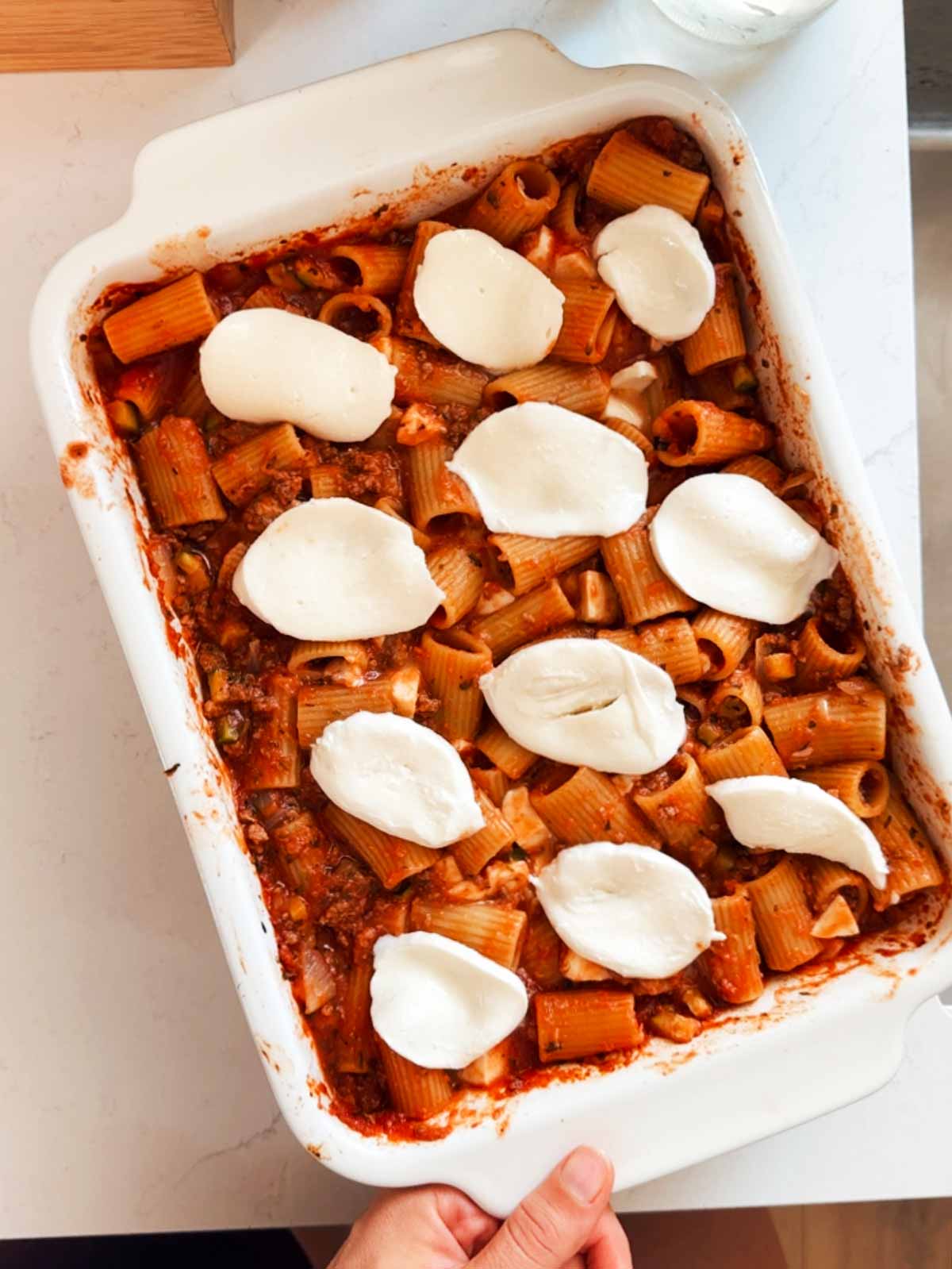Pasta casserole with cold mozzarella slices on top.