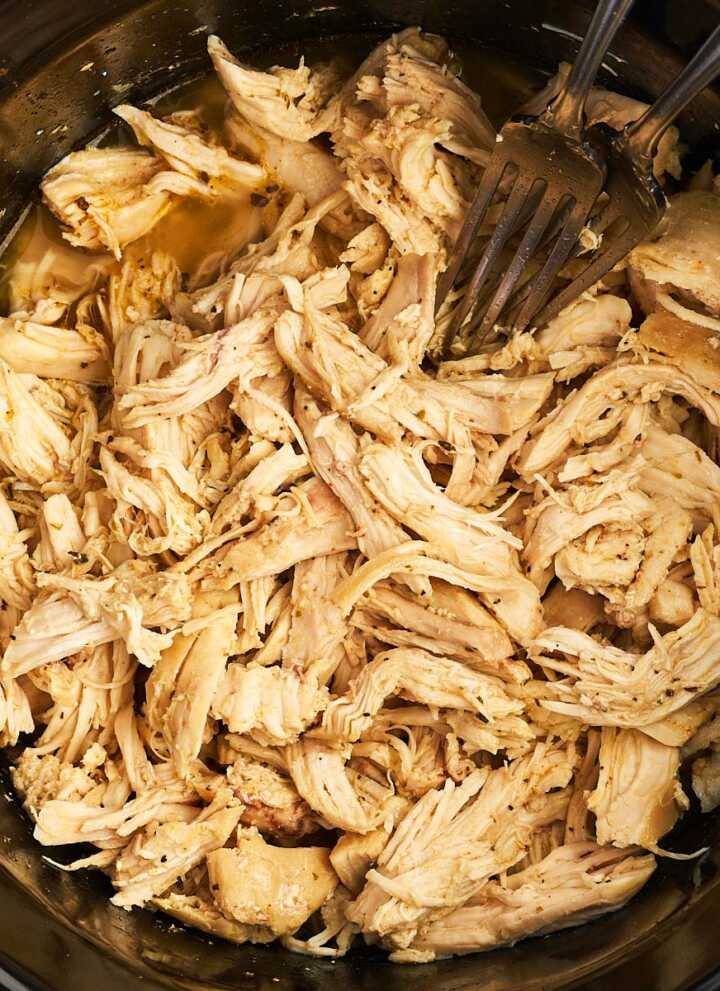 Overhead view of shredded chicken in a crockpot.
