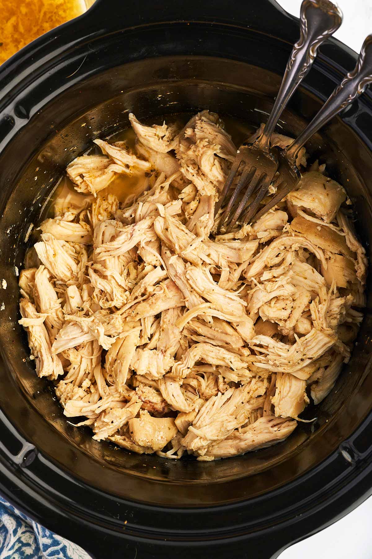 Overhead view of shredded chicken in a crockpot.