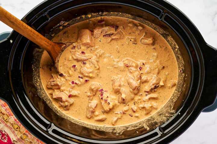 Uncooked chicken curry in slow cooker.
