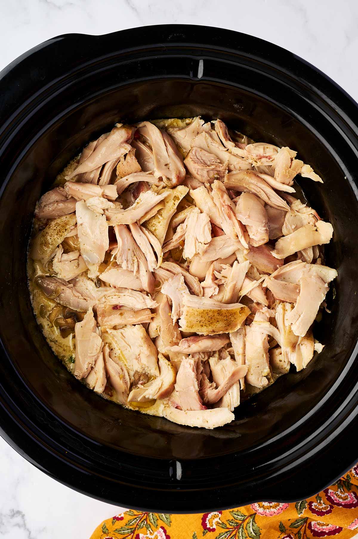 Shredded chicken in slow cooker.