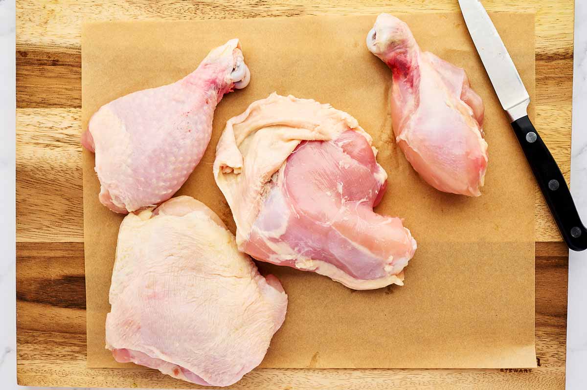 Removing chicken skin from chicken leg pieces.