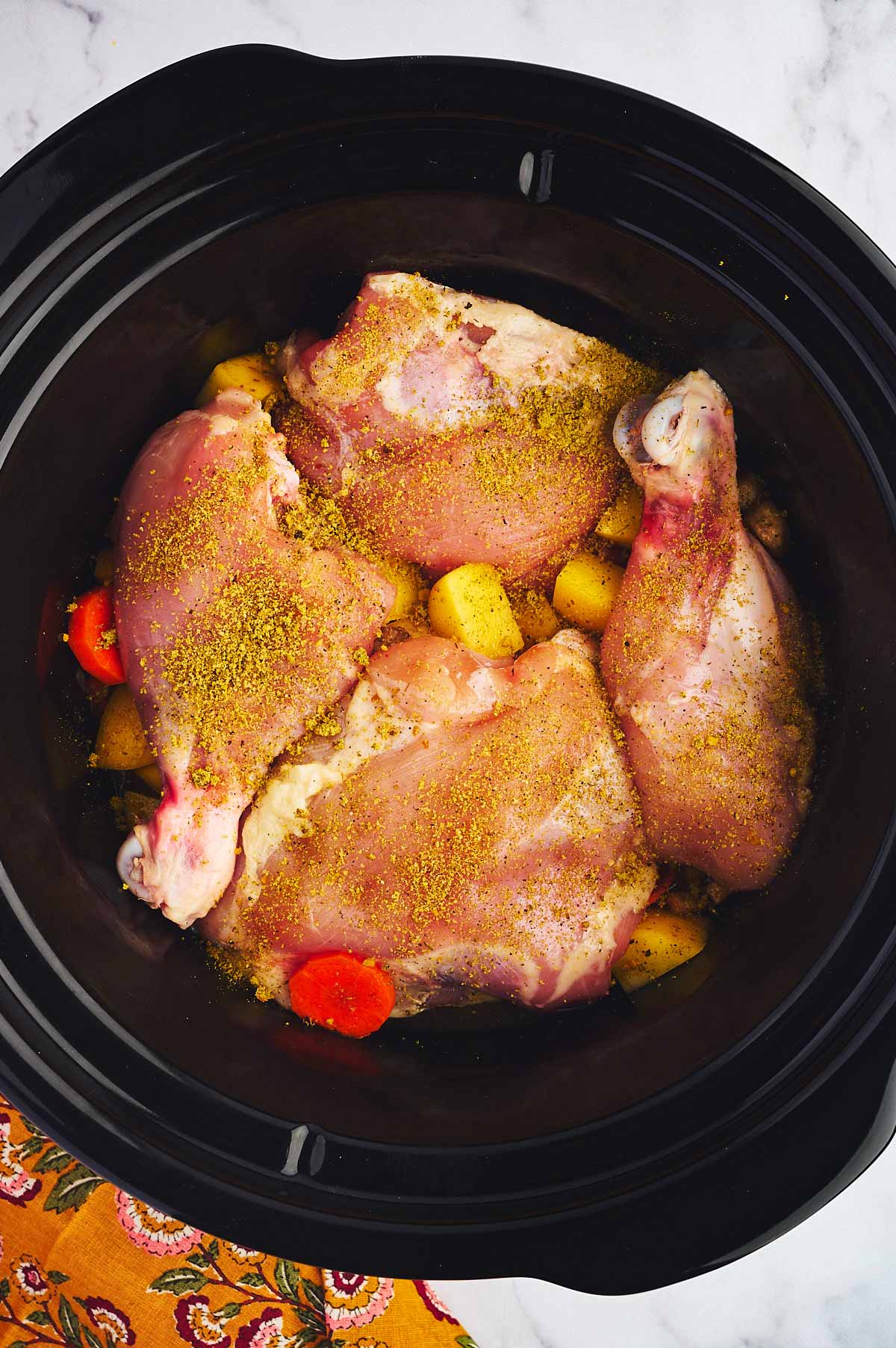 Assembled chicken stew, uncooked in slow cooker.