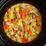Slow cooker with chicken stew inside.
