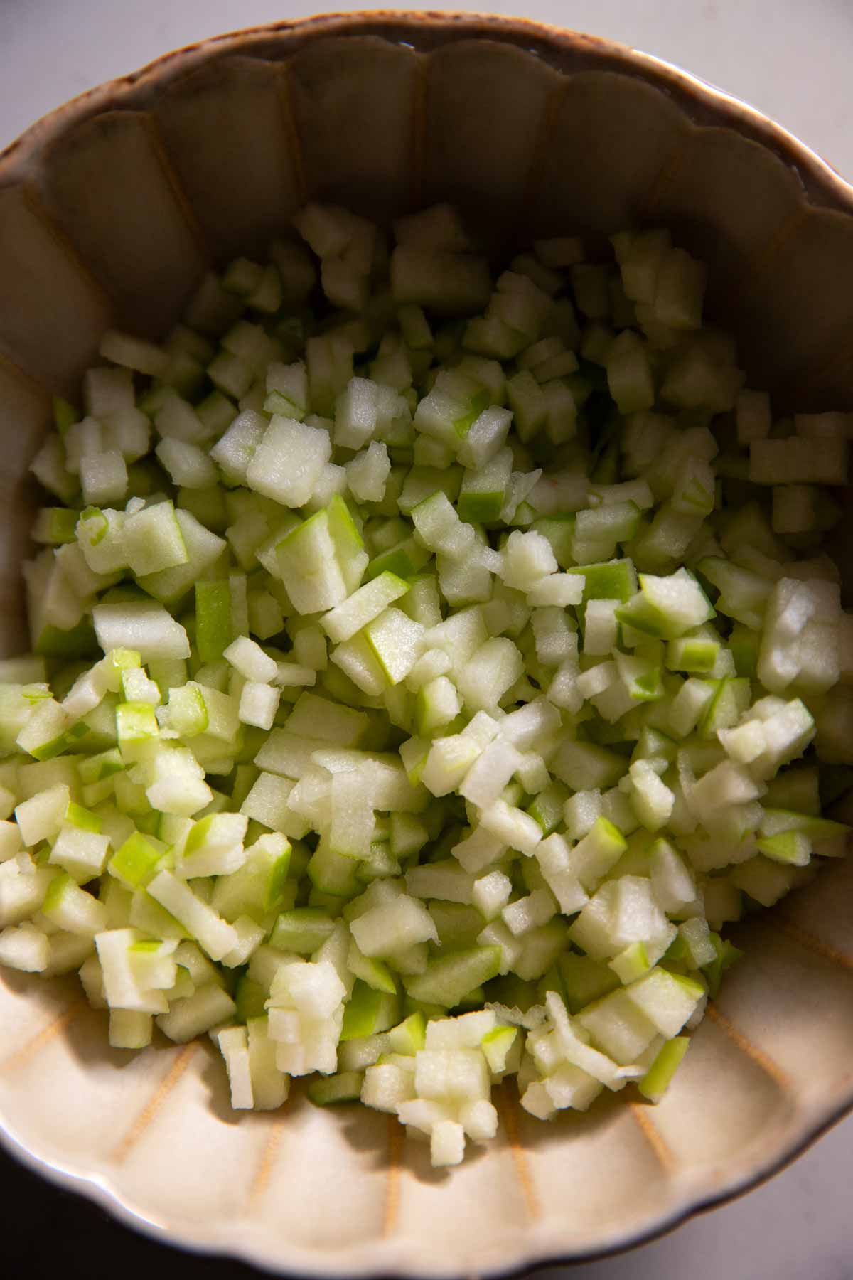 Finely chopped apple in a bowl.
