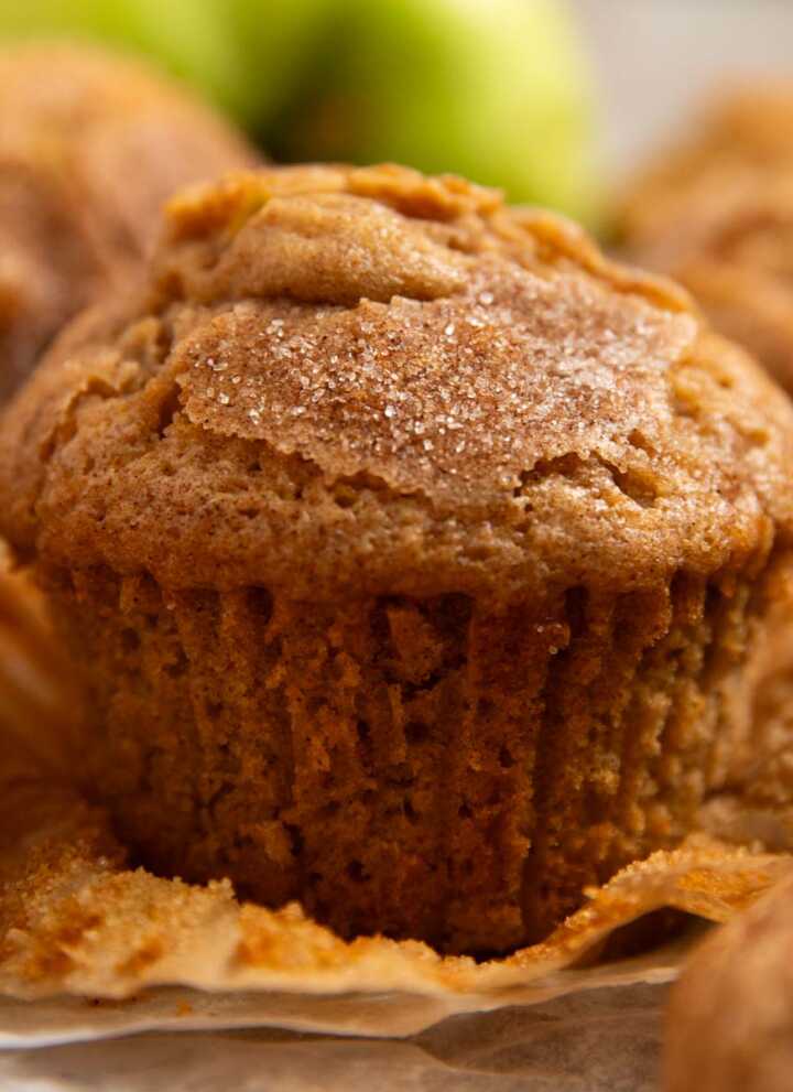 Apple muffin on a wooden board with the wrapper unwrapped.