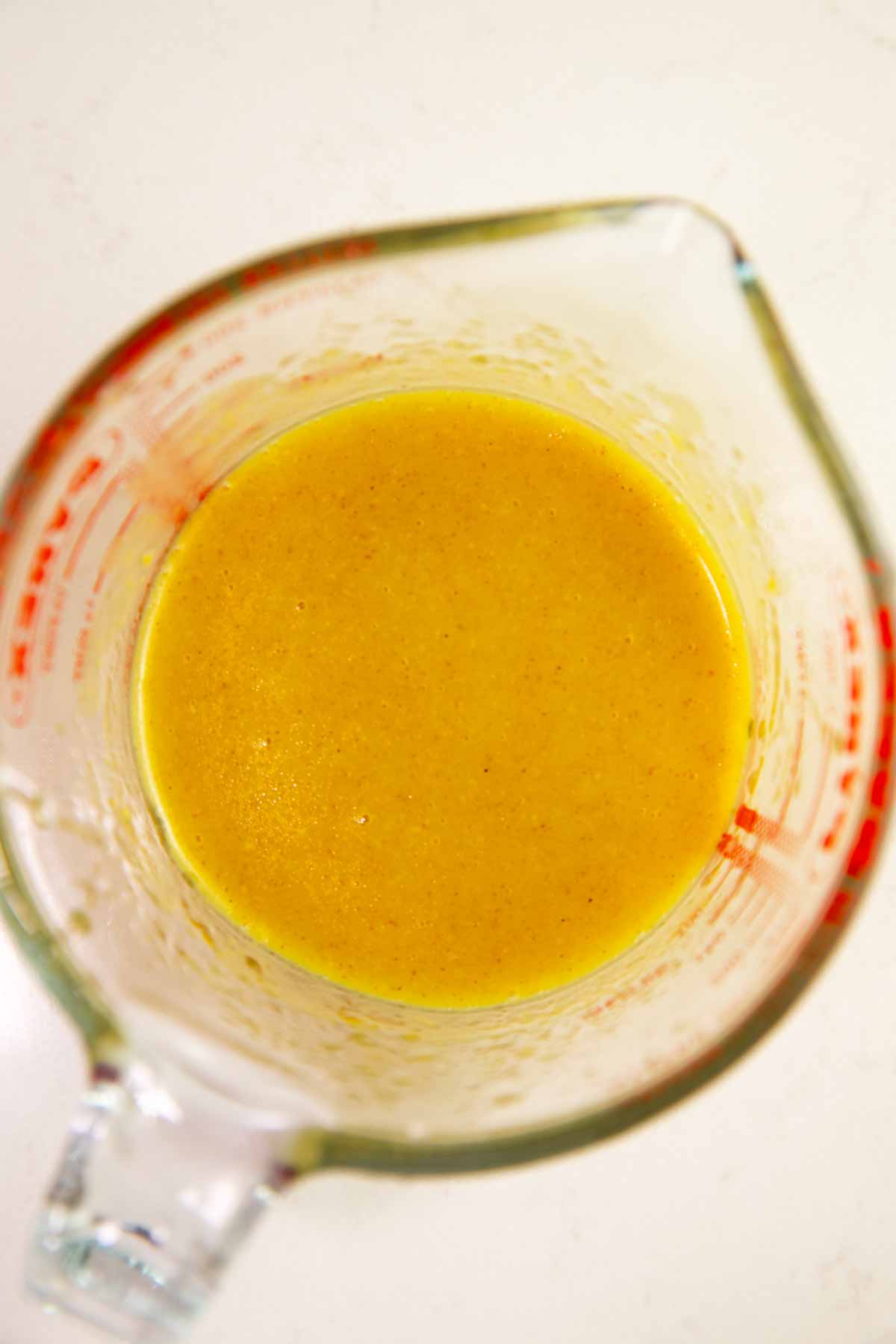 Lemon glaze in a measuring cup.