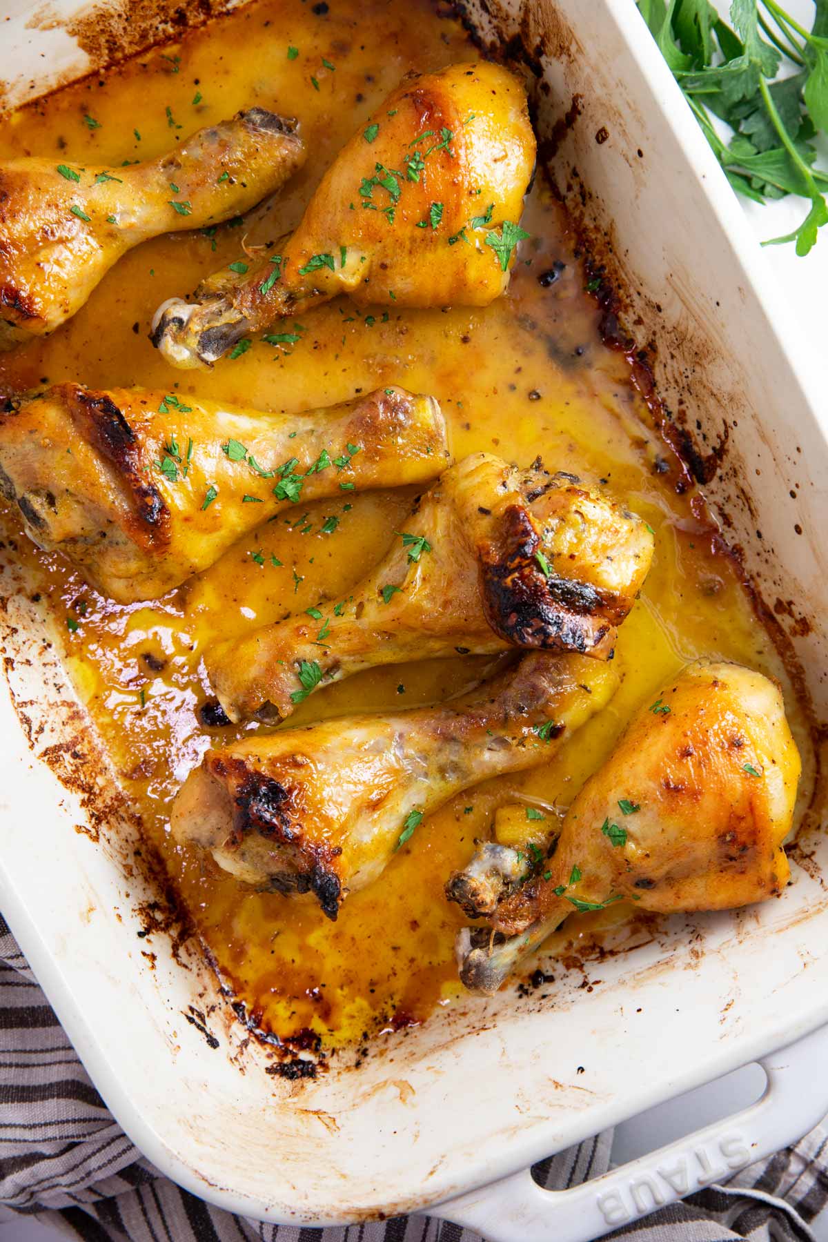 Casserole dish with baked chicken legs.