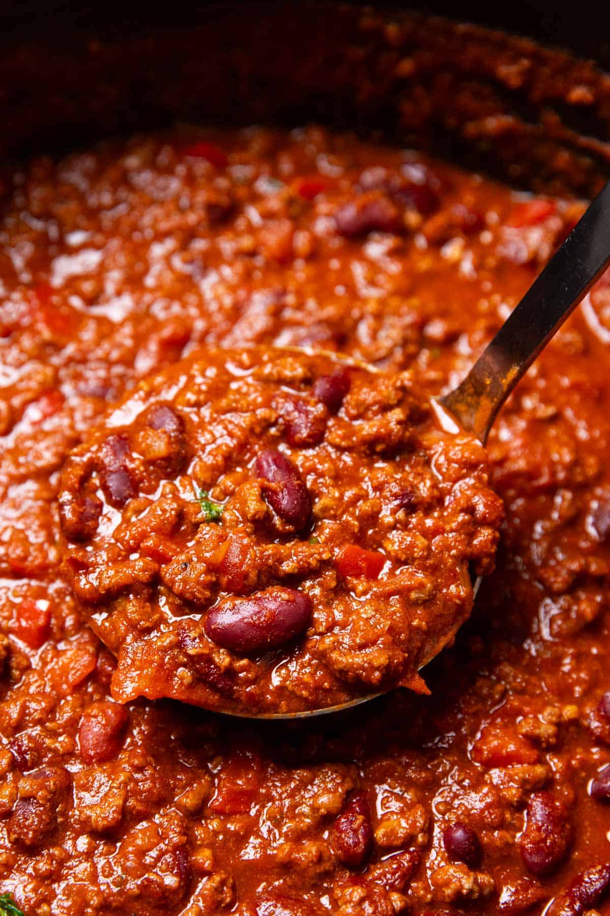 Close up of a ladle with chili.