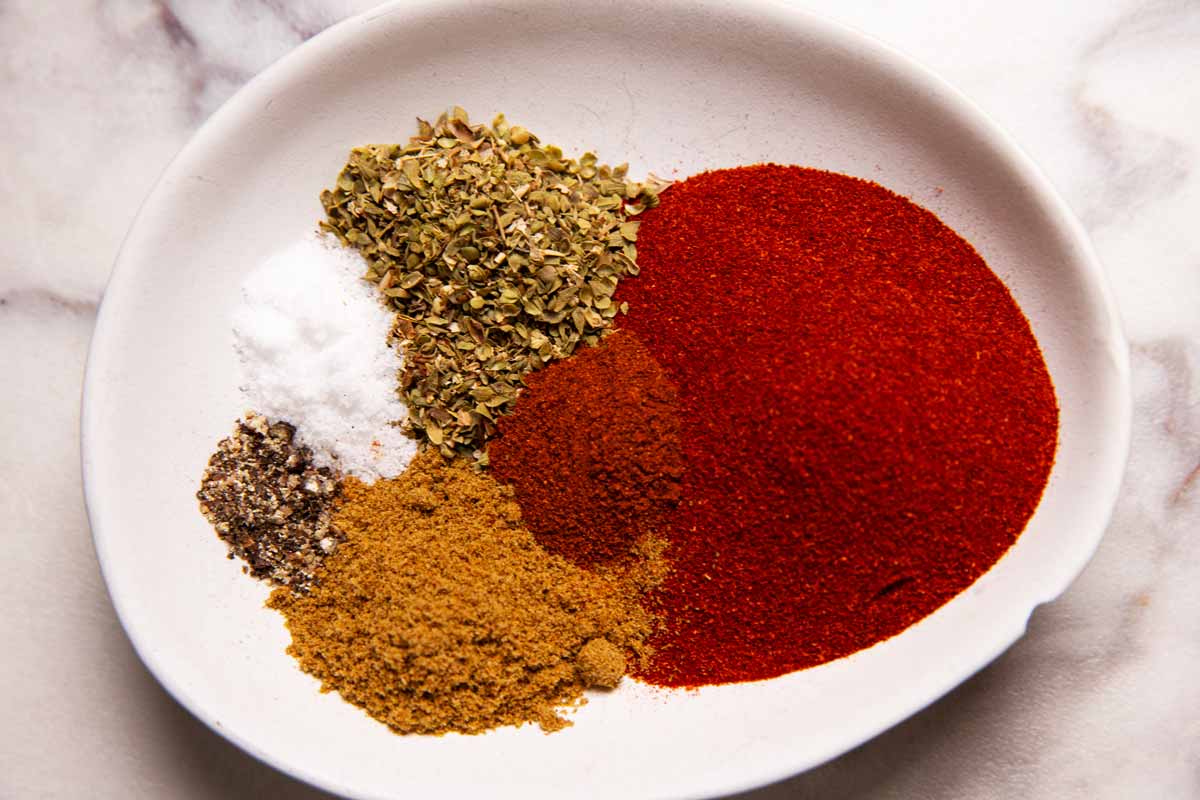 Ingredients for chili seasoning in a white bowl.