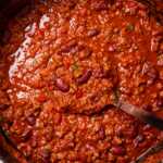 Pot of chili with ladle inside.