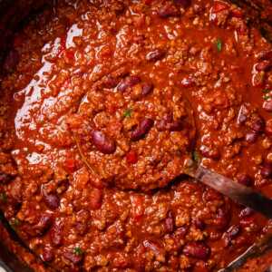 Pot of chili with ladle inside.