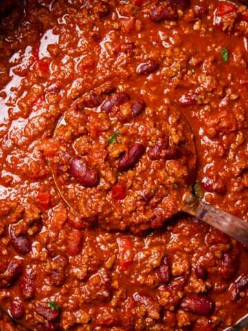 Pot of chili with ladle inside.