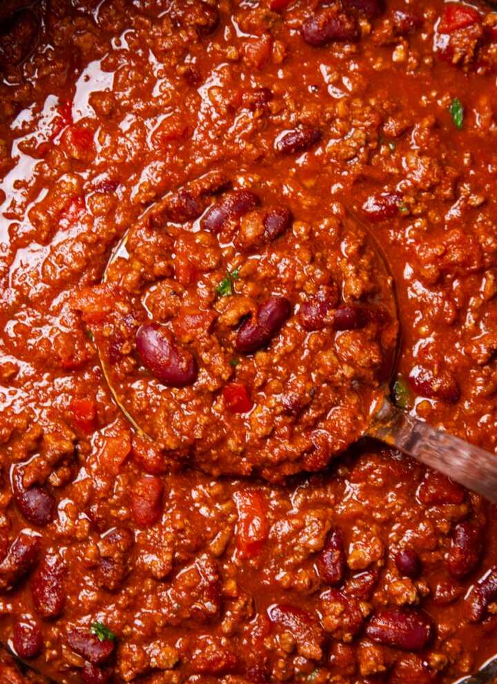 Pot of chili with ladle inside.