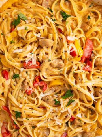 Overhead view of an enameled cast iron pan filled with Creamy Cajun Chicken Pasta.