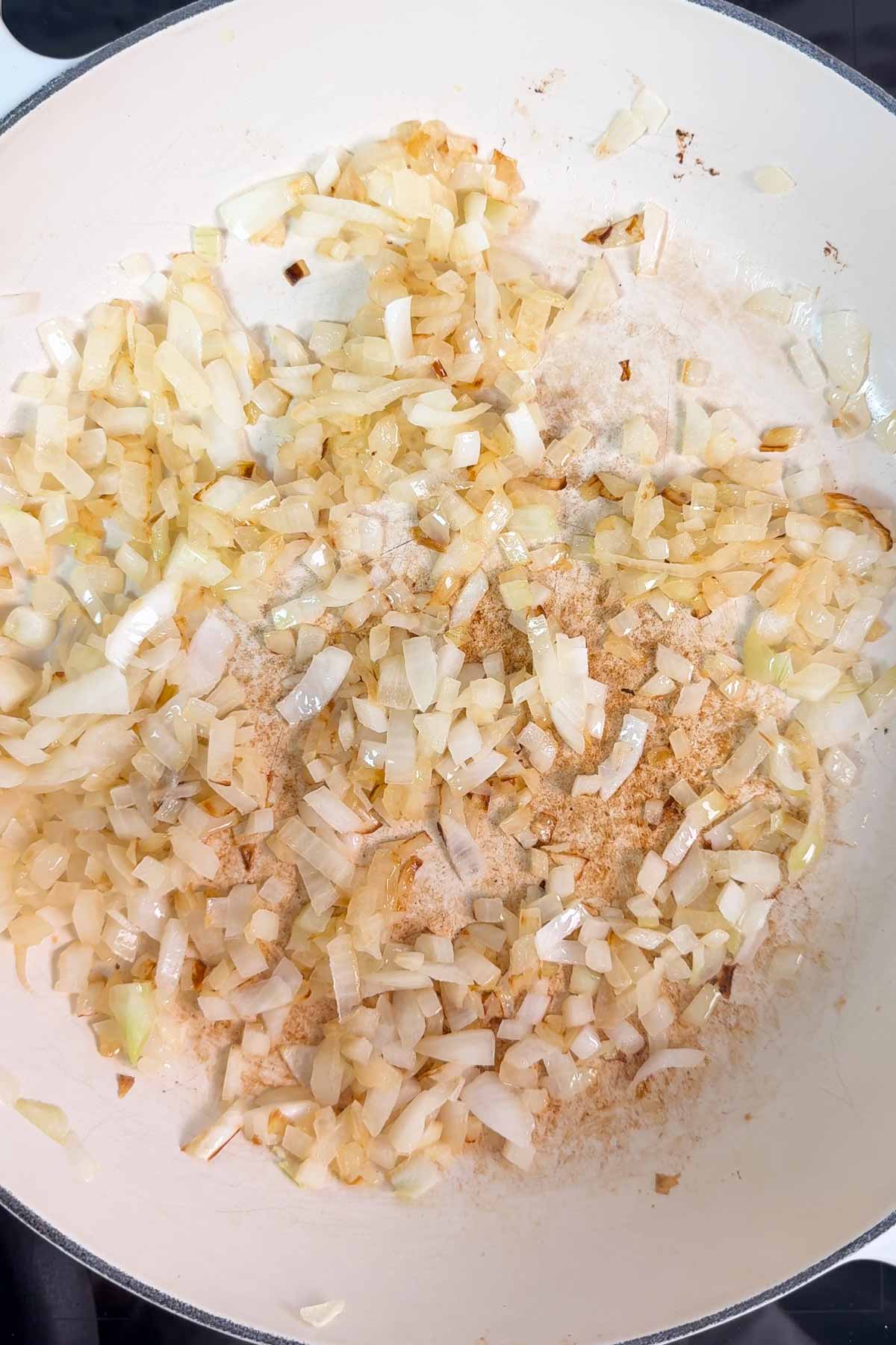 Sautéed onion in a white pan.