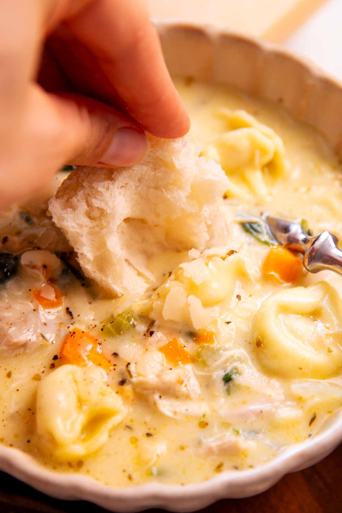 Dipping bread in a bowl of soup.