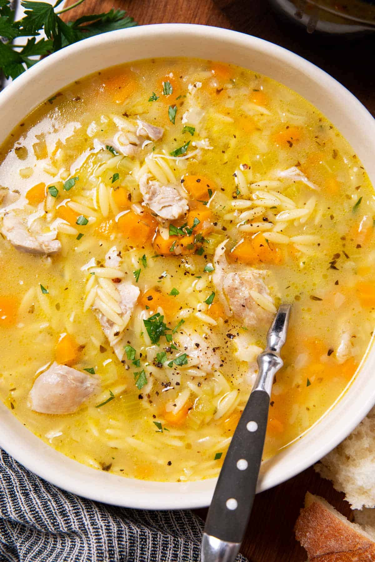 White soup bowl filled with lemon chicken orzo soup.